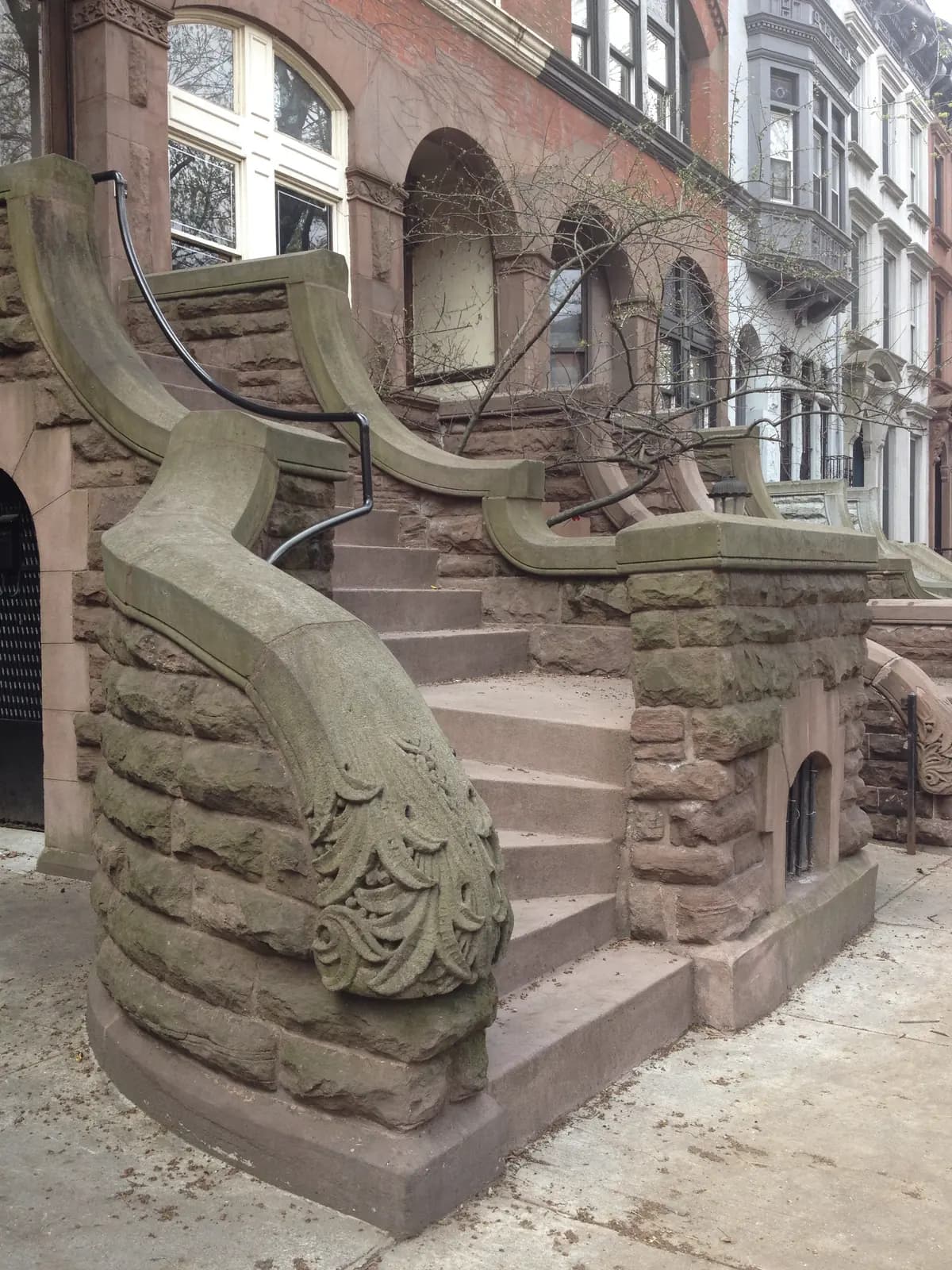 Carved brownstone steps curving up to a row of townhouses in Park Slope, Brooklyn